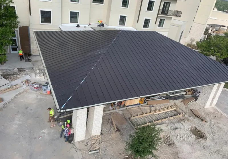 Metal roofing installation team working on a commercial building in Vernon